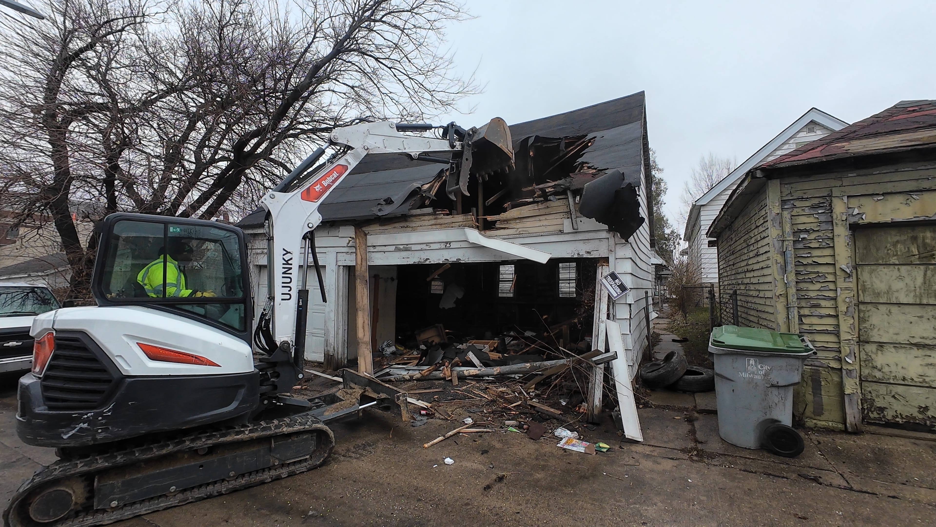 Garage demolition action shot showing machine, structure, and debris area in Milwaukee