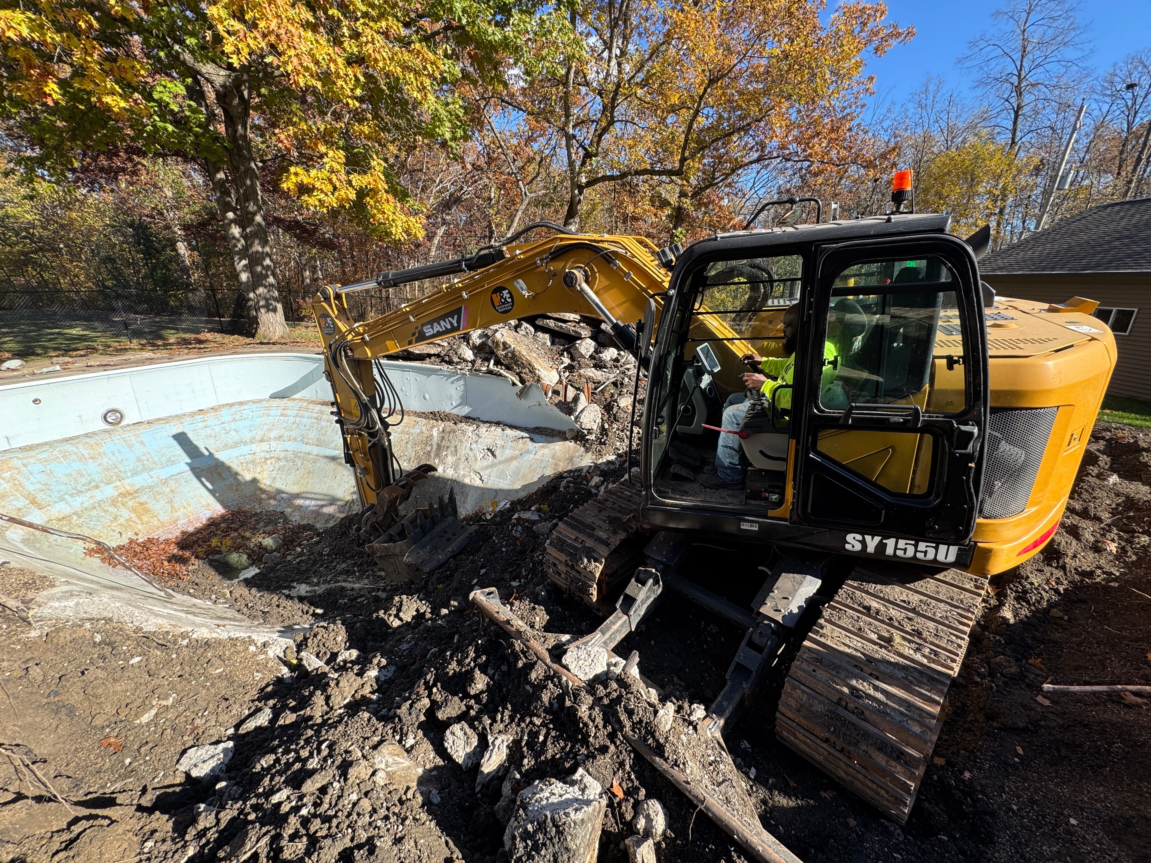 Pool demolition excavator action shot in Milwaukee