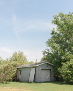 An image of a white wooden shed outdoors